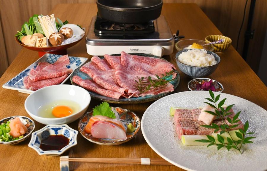 A full sukiyaki course with marbled wagyu, sashimi, egg, rice and vegetables